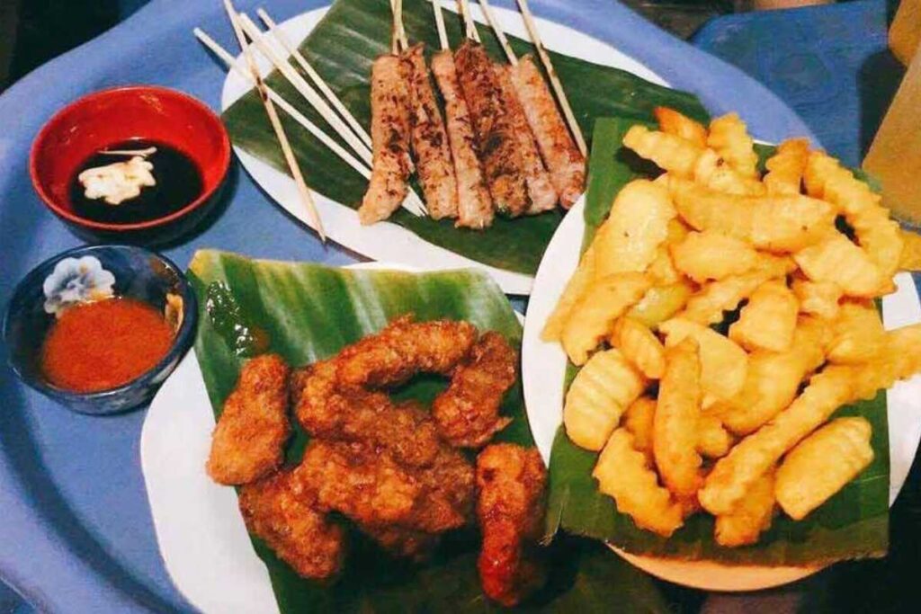 Mẹt ăn vặt gồm nem chua rán, khoai tây chiên và thịt xiên nướng tại quán Nem chua Phượng