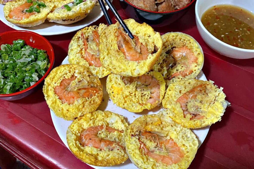 Đĩa bánh căn mực tươi rói và nước chấm xíu mại tại quán Cô Tám 98 Cù Huân Nha Trang.