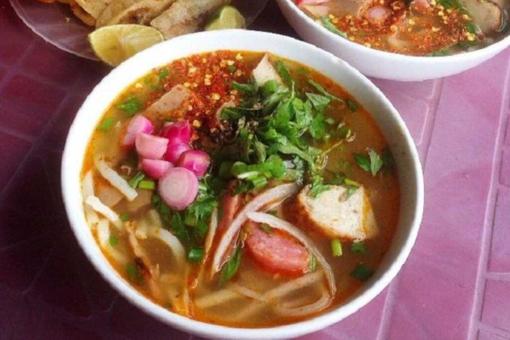 Tô bánh canh cá nướng nóng hổi với trứng cút và hành tím muối tại quán Hà Thị Thân.