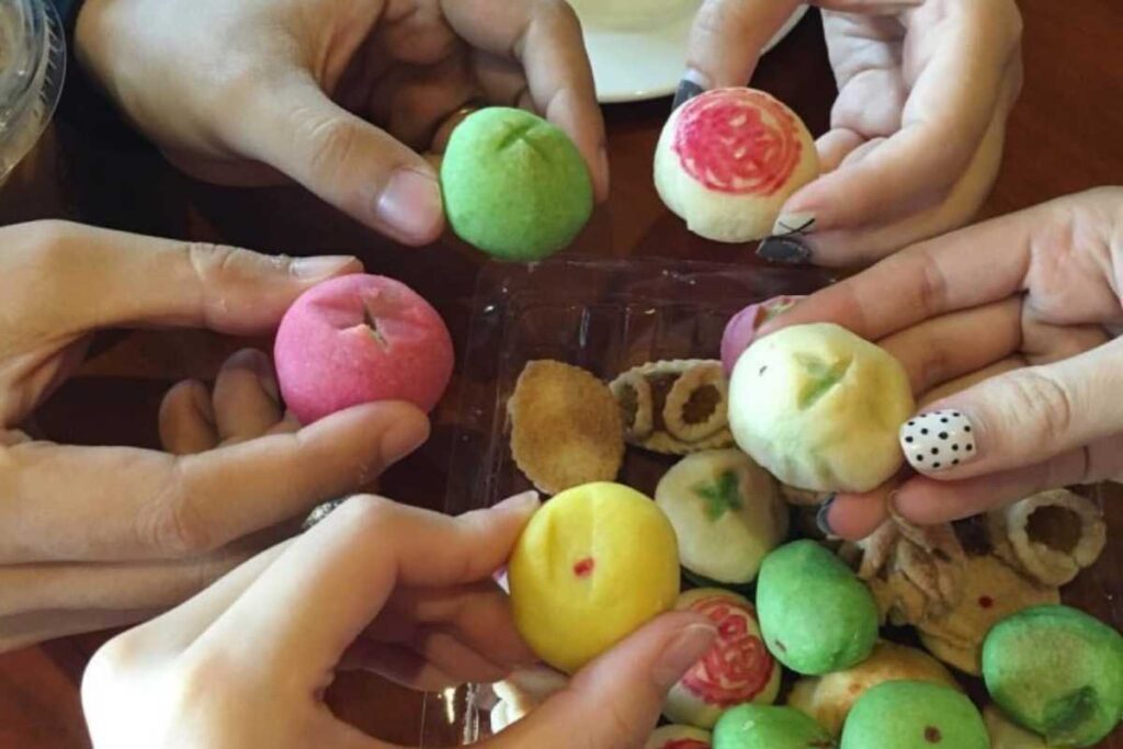 Các bạn trẻ cùng cầm trên tay những chiếc bánh khéo nhỏ xinh nhiều màu sắc của tiệm Cô Dung.