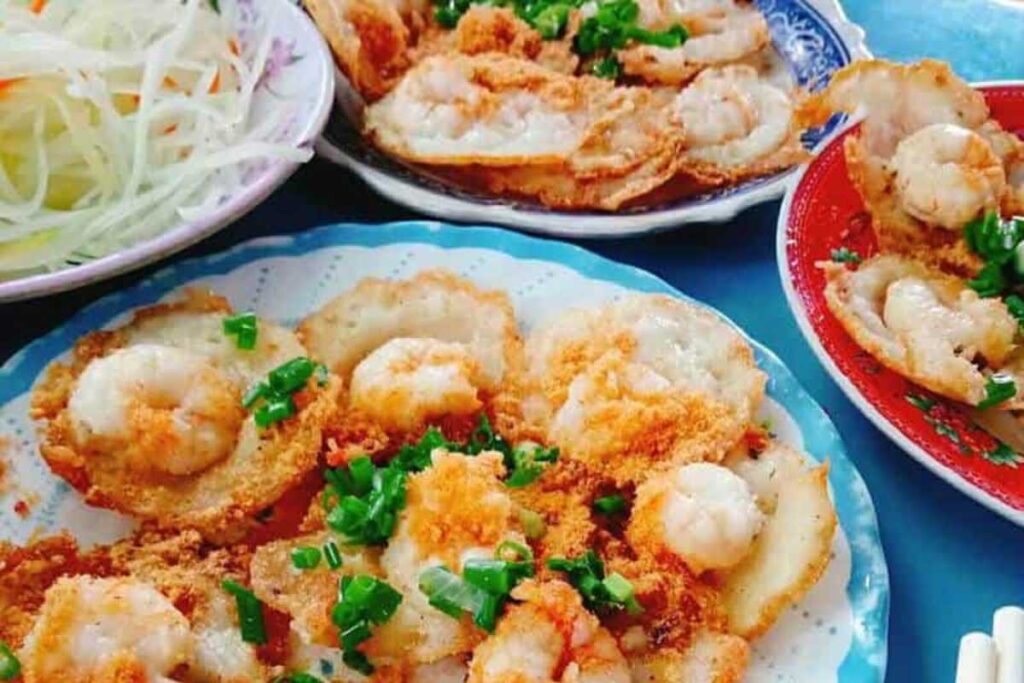 Đĩa bánh khọt vàng ươm với nhân tôm tươi và hành lá phục vụ kèm rau sống tại quán Hương Lan.