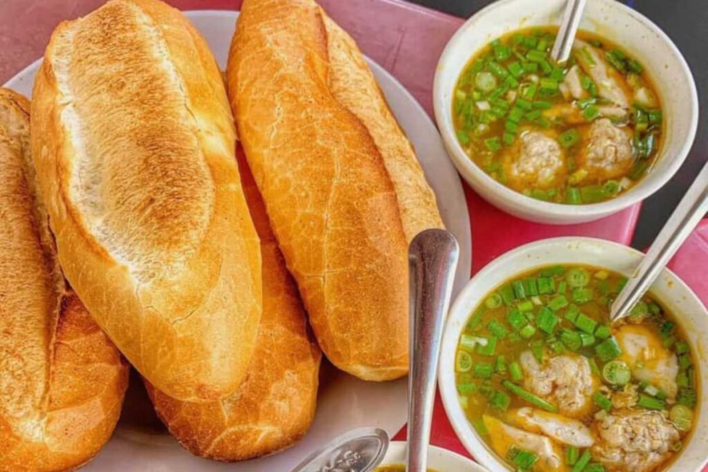 Những ổ bánh mì giòn tan đặt cạnh bát xíu mạ ngập sốt đỏ cam bắt mắt tại tiệm bánh mì Lý Tự Trọng.