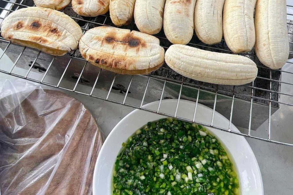 Chuối nếp nướng trên vỉ than hồng cạnh bát mỡ hành xanh mướt đặc trưng vỉa hè Phú Quốc.
