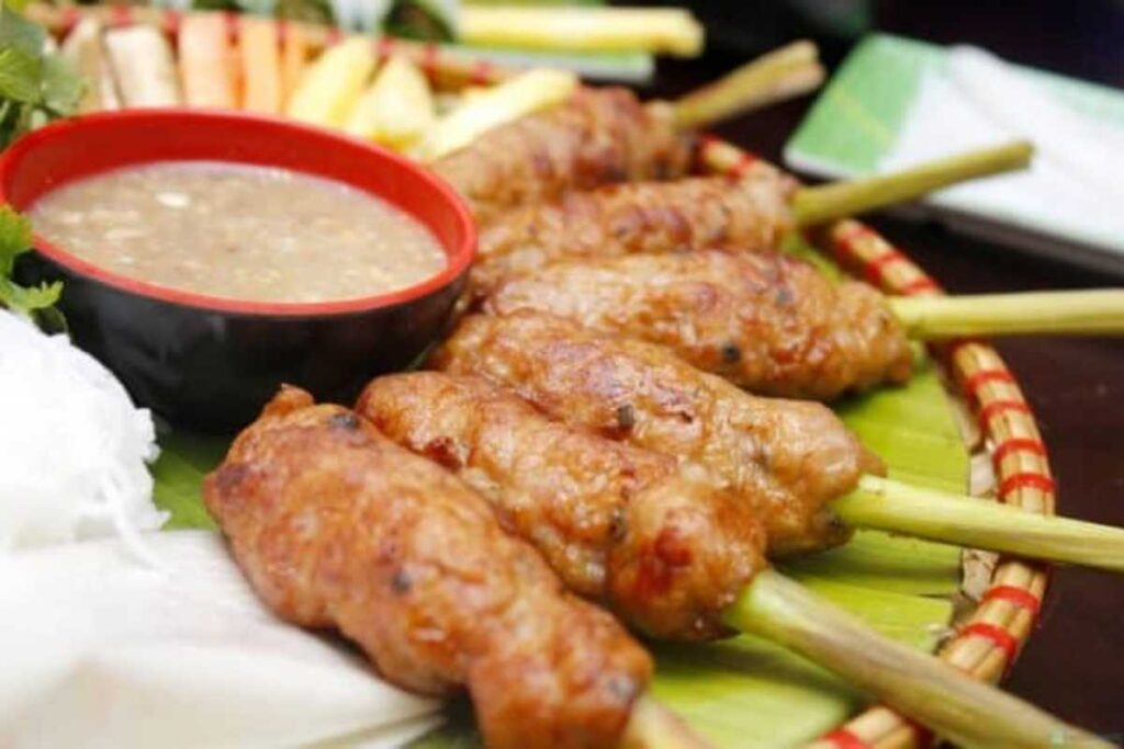 Những xiên nem lụi nướng vàng ươm ăn kèm rau sống và nước tương đậu phộng tại quán Bà Hường.