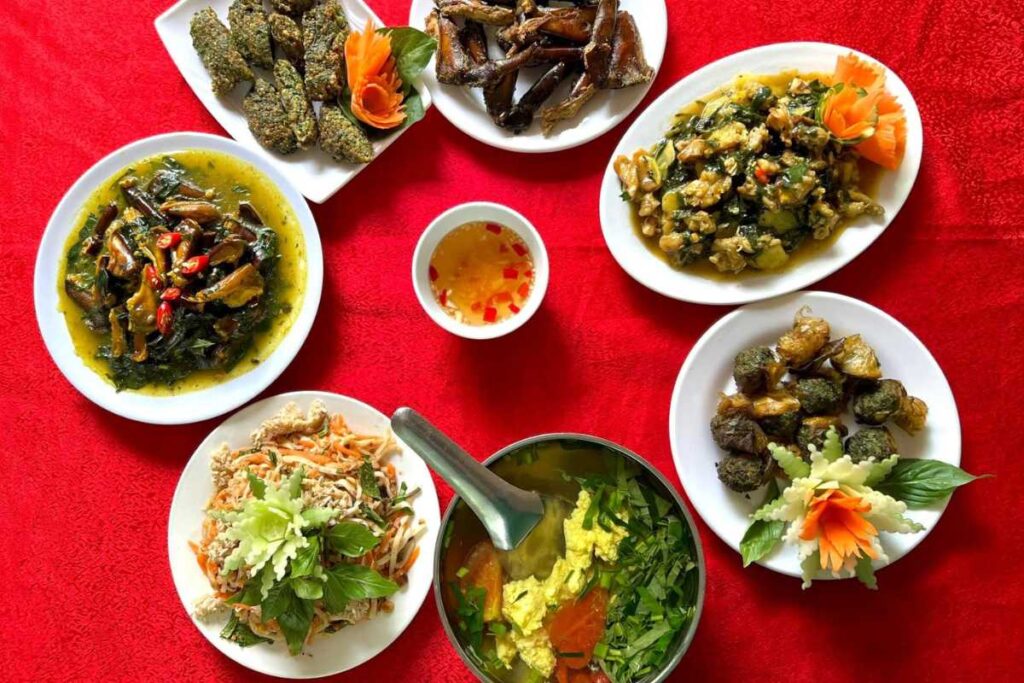 Các món chế biến từ sam biển: sam xào dứa, sam nướng, súp sam được bày trên đĩa trên bàn đỏ.