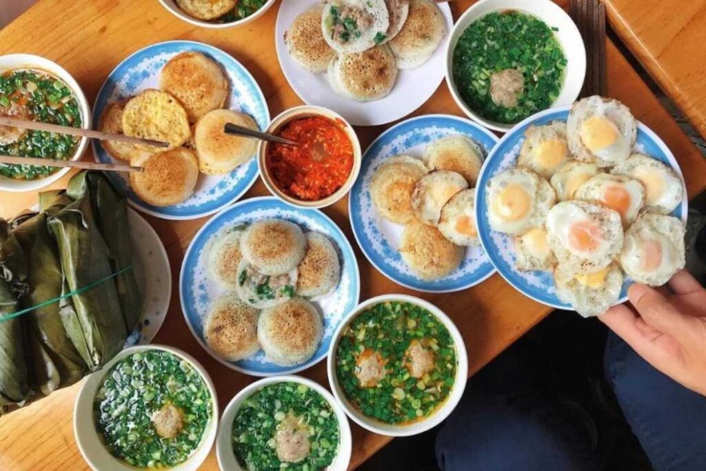 Đĩa bánh căn nóng hổi nhân trứng cút và xíu mại tại quán Bánh Căn Lệ Đà Lạt.