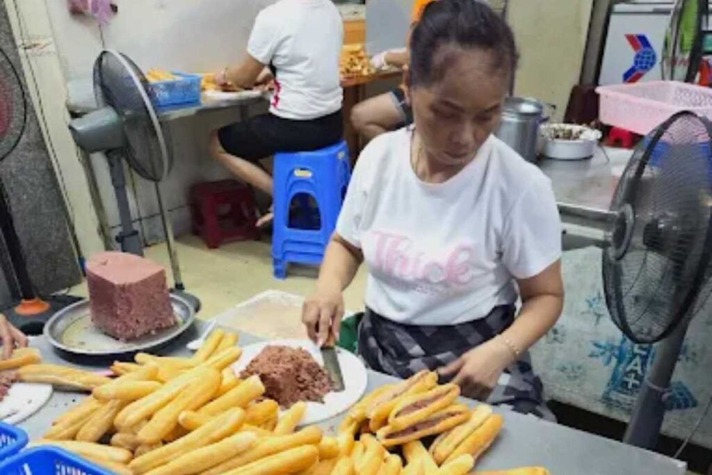 Cận cảnh lớp pate mịn màng béo ngậy được phết đều bên trong ổ bánh mì que nóng hổi tại tiệm Bà Già Lê Lợi.