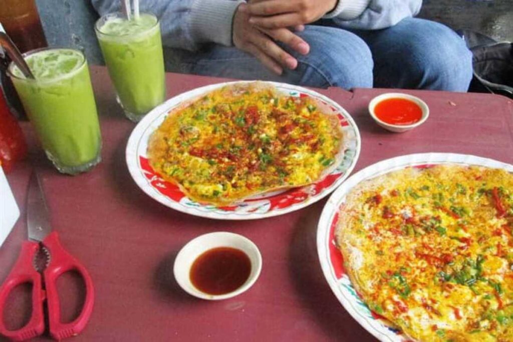 Đĩa bánh căn nóng hổi nhân trứng cút và xíu mại tại quán Bánh Căn Lệ Đà Lạt.