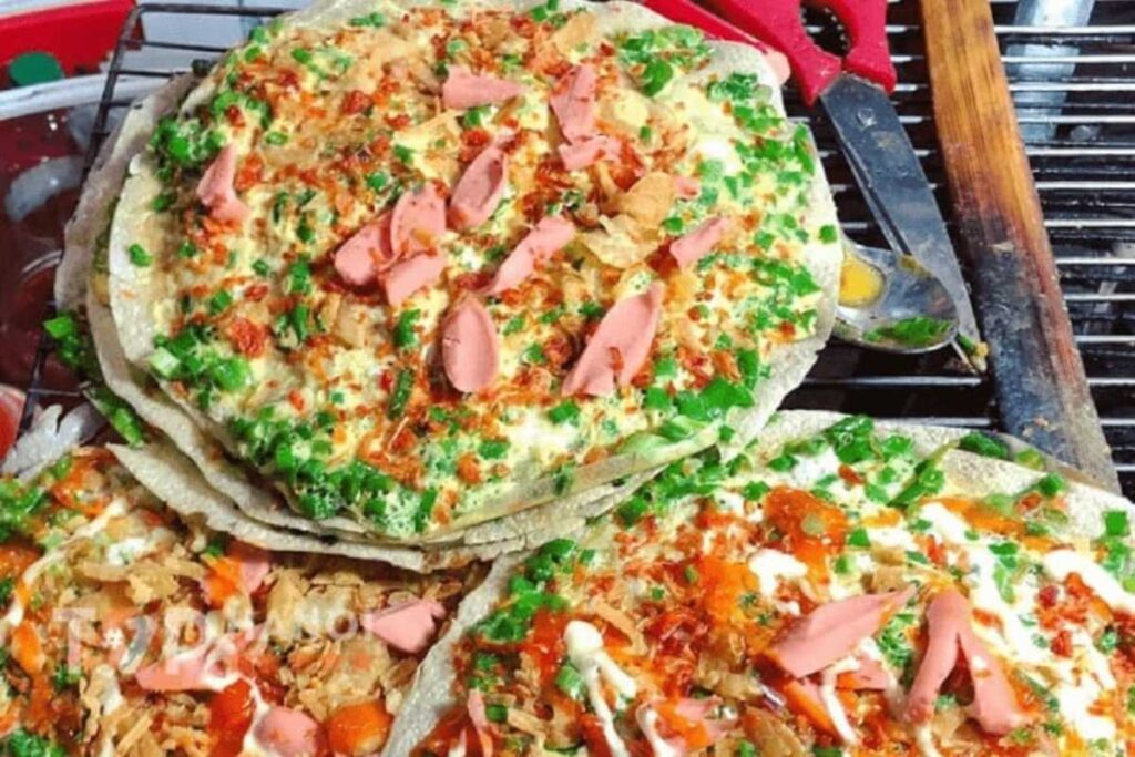Chiếc bánh tráng nướng đầy đặn phô mai và xúc xích tại ngã ba Mạc Đĩnh Chi Nha Trang.