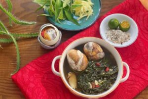 Bát trứng vịt lộn hầm ngải cứu và bát muối tiêu chanh bày trên bàn gỗ chợ Hạ Long.